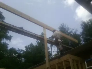 Carpenter setting a ridge beam over a new addition frame — Ice Dam Removal by Roofing Brothers in Moonachie
