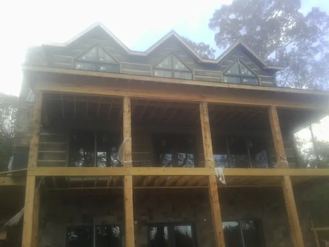 Dormers and porch framing on a large log home under construction — Roof Coating work by our crew in Moonachie