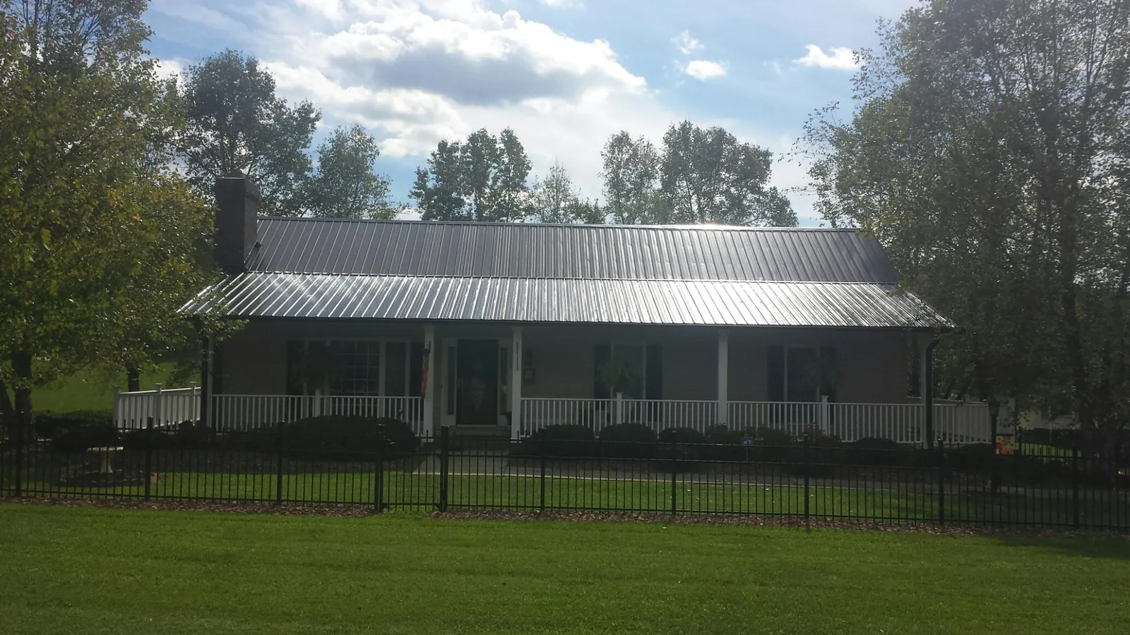 Gray metal roof on a brick ranch with a full width front porch — Gutter Guard Installation work by our crew in Moonachie