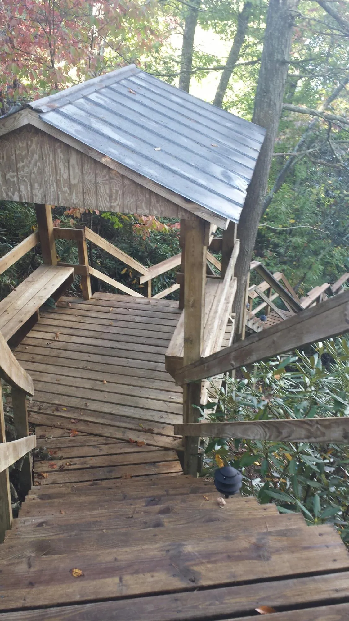 Metal roofed shelter over wooden steps on a wooded walkway — Skylight Repair & Installation work by our crew in Moonachie
