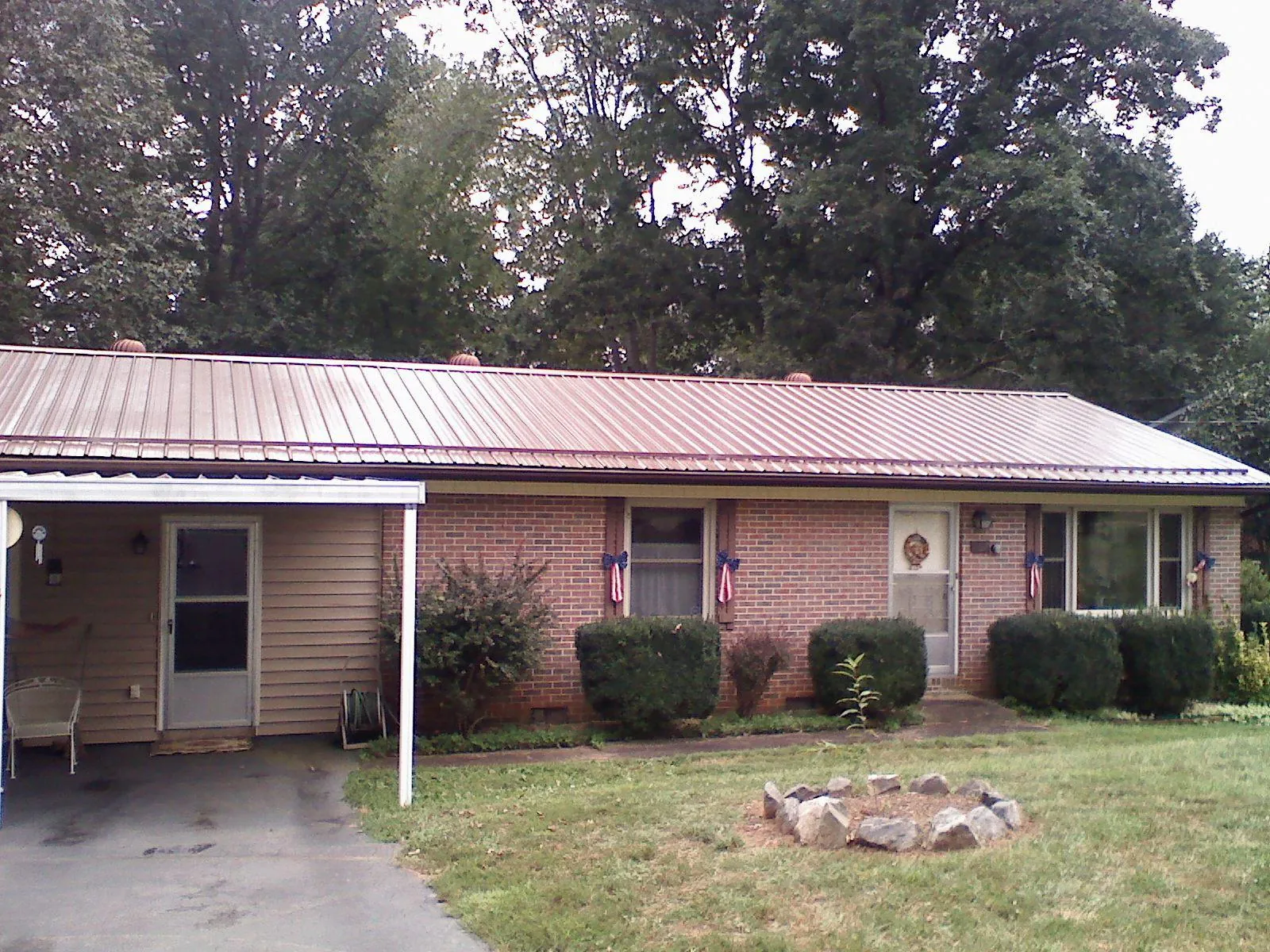 Bronze metal roof and carport on a brick ranch home — Roof Repair work by our crew in Moonachie